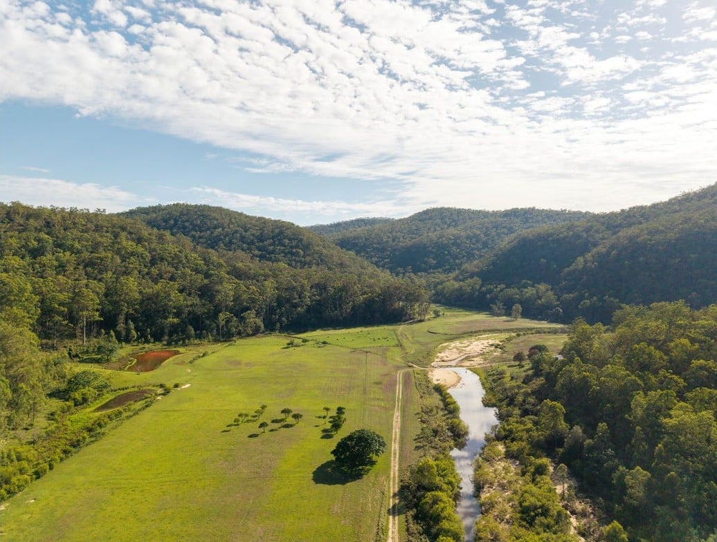 Aerial view down the Webbs Creek valley, cleared flats between forested sandstone ranges